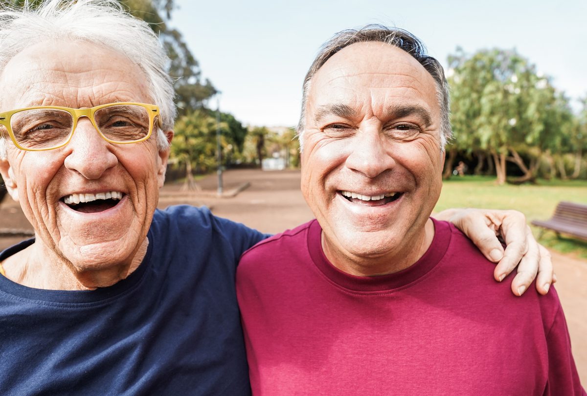 Three older Australians walking together along a tree-lined path in autumn