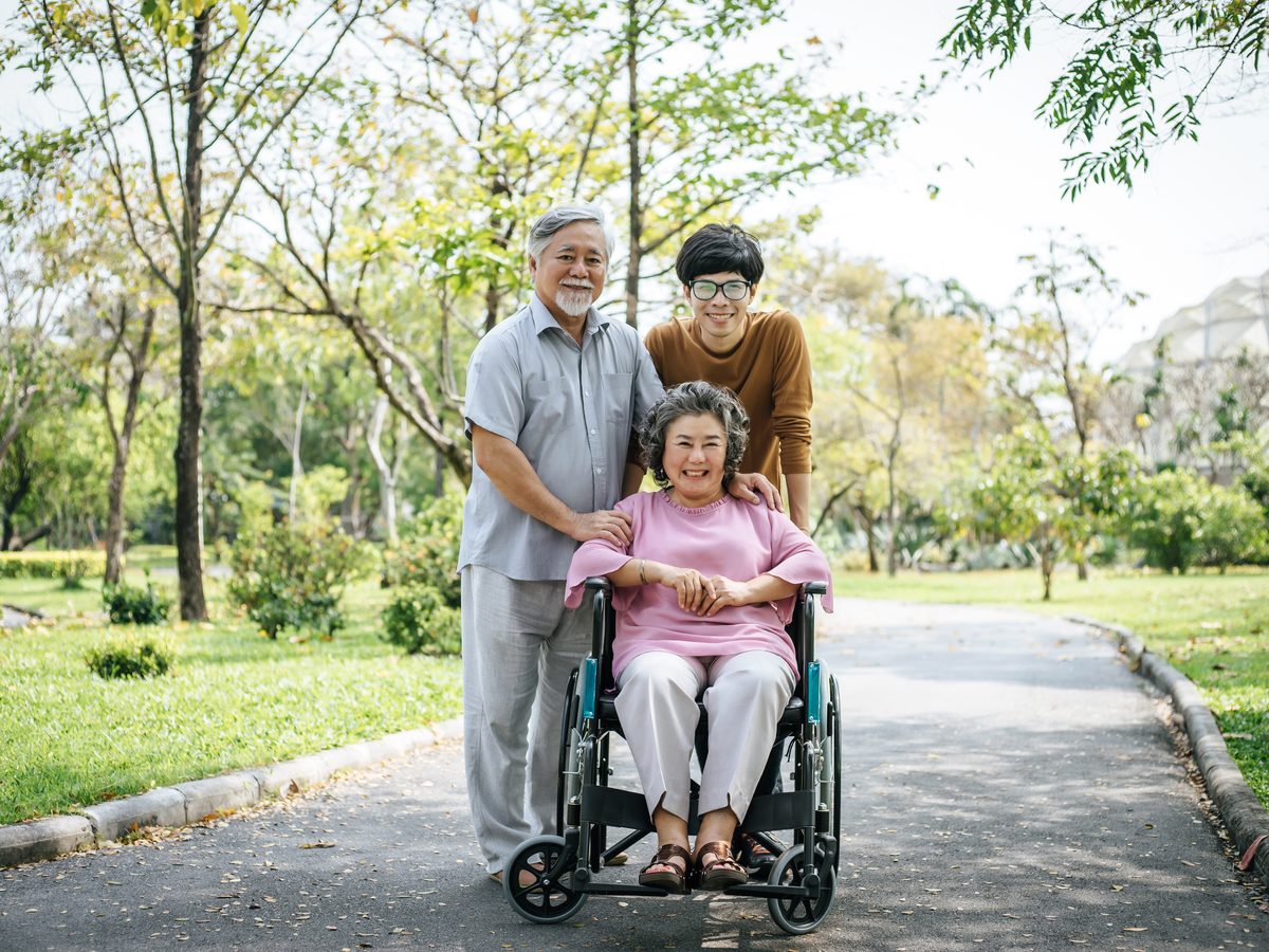 Older Australian with family members, all smiling together outdoors