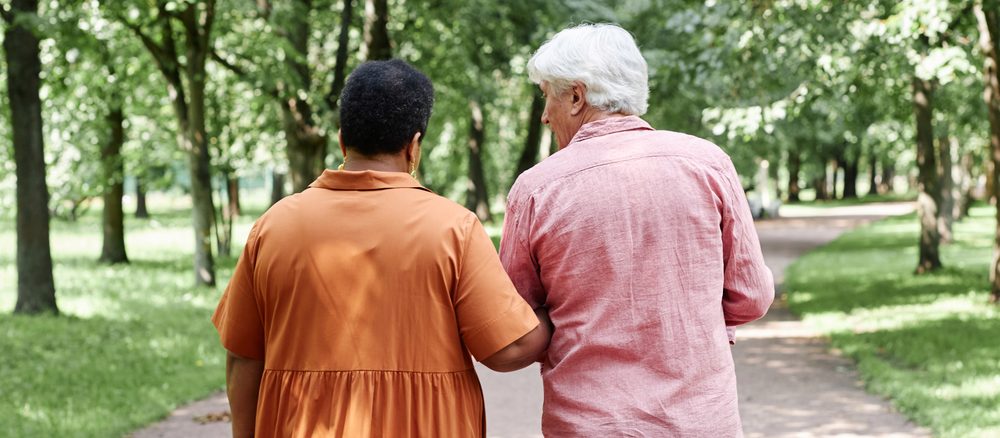 Care Guidance team member walking with an older Australian in a park