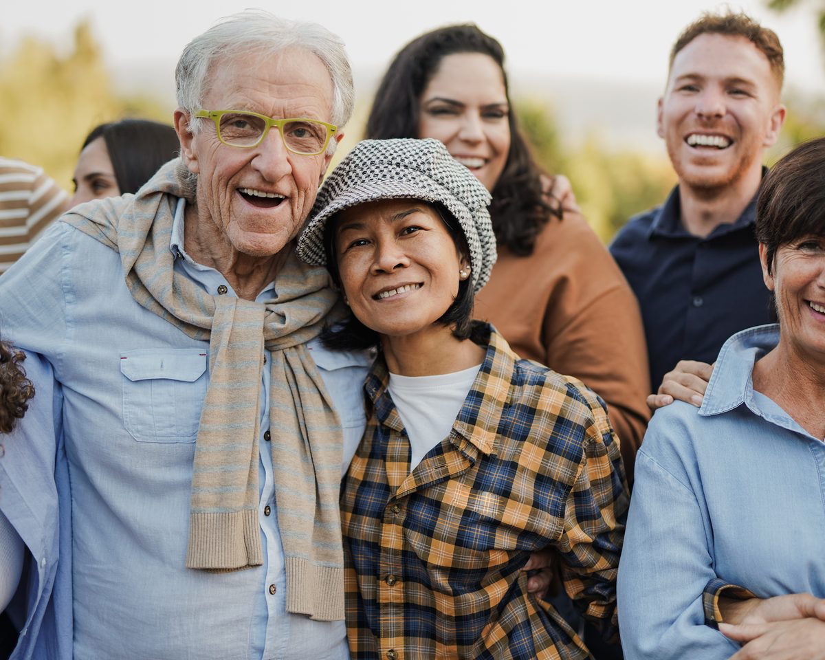 Older Australian smiling with family members outdoors in warm natural light