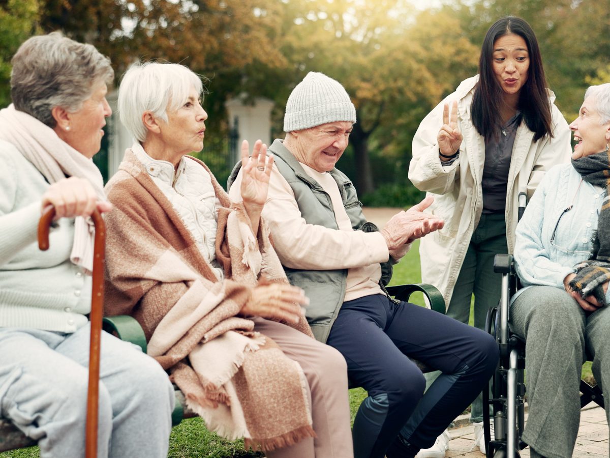 Wellbeing Specialist supporting a group of older Australians outdoors